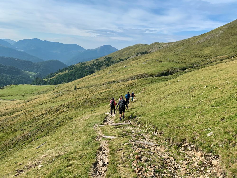 Photo of a family hiking in a green meadow